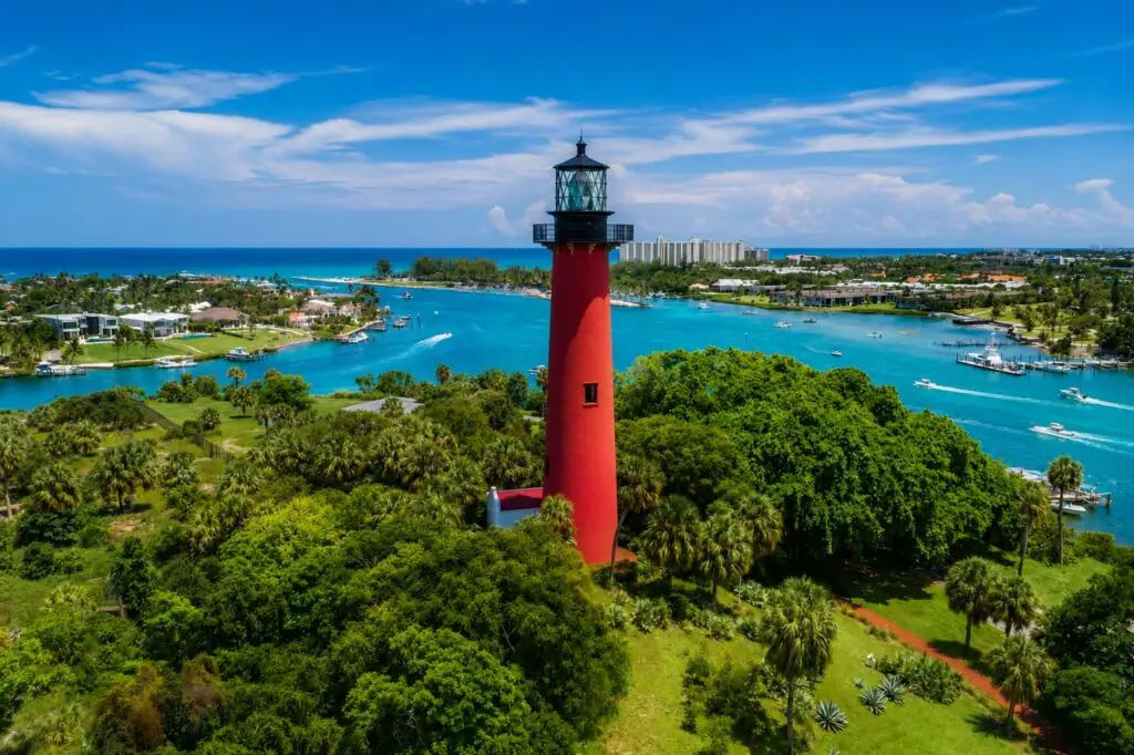 Jupiter Inlet Lighthouse surrounded by palm trees and waterway in Jupiter, Florida